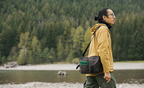 Person walking next to a river, wearing the LGD as a shoulder carry bag.